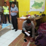 Polisi saat melakukan olah tempat kejadian perkara di dalam rumah kos korban di Desa Purwosari, Bojonegoro. foto: EKY NURHADI/ BANGSAONLINE