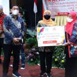 Gubernur Jawa Timur Khofifah Indar Parawansa terus memberi spirit dan fasilitas termasuk modal untuk pengembangan koperasi kecil dan UMKM. Tampak Gubernur Khofifah menyerahkan bantuan modal dalam Rapat Koordinasi Program Prioritas Pemberdayaan Koperasi Usaha Kecil dan Menengah (K-UKM) Jatim di Hotel Aria Gajayana Malang, Kamis (10/6) tadi malam. Foto: ist