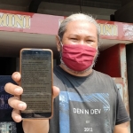Beny Prasetya, salah satu Pengusaha Pom Mini di Desa Wates, Kecamatan Pagu, Kabupaten Kediri saat menunjukkan pesan berantai di aplikasi WhatsApp miliknya. foto: MUJI HARJITA/BANGSAONLINE