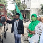 Wakil Ketua MWC NU Siran bersama anggota Fatayat dan Muslimat membagikan masker dan jamu kesehatan kepada para pengendara.