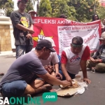 Massa Gepal ketika menggelar demo di kantor DPRD Gresik sambil makan nasi bungkus. foto: SYUHUD/ BANGSAONLINE