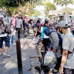 Para ASN Pemkot Batu saat membersihkan sampah di Jalan Dewi Sartika, depan Pasar Besar Kota Batu.