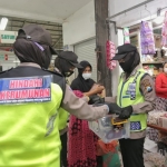 Para polwan yang sedang membagikan masker di salah satu pasar Lamongan.
