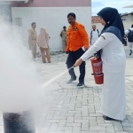 Para karyawan RSUD Waru Pamekasan baik laki-laki dan perempuan belajar menggunakan APAR untuk mengatasi kebakaran.