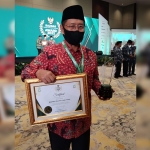 Ketua Baznas Jatim, KH Muhammad Roziqi, saat menerima penghargaan Baznas Award 2022 dari Ketua Baznas RI, H Noor Achmad. Foto: Ist