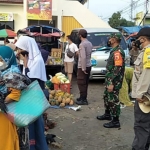 Anggota Koramil Jogorogo saat memberikan sosialisasi prokes di pasar tradisional.