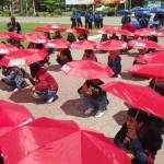 SINDIR PEMERINTAH: Parade Seribu Payung yang digelar Buruh Sidoarjo terkait aksi May Day, di alun-alun Sidoarjo, Minggu (1/5). foto: mustain/ BANGSAONLINE