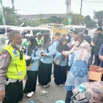 Wakasatlantas Polresta Sidoarjo, AKP Meita Anisa bersama para personel saat membagikan makanan dan minuman kepada para jemaah Resepsi Harlah Satu Abad NU, Selasa (7/2/2023)