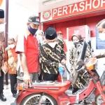 LAYANI WARGA: Abdul Halim Iskandar mengisi BBM ke salah satu motor warga saat mengunjungi usaha milik BUM Desa di Desa Jemirahan Jabon, Jumat (3/9/2021). foto: istimewa