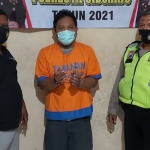 Tersangka Edy diapit petugas Polsek Gedangan, Sidoarjo.