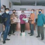 Petugas saat menyerahkan bantuan sembako kepada warga yang sedang menjalani isolasi mandiri. (foto: ist.)