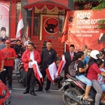 Ketua DPC PDIP Gresik Mujid Riduan bersama Sekretaris Noto Utomo dan para pengurus saat membagikan bendera merah putih kepada pengguna jalan. foto: SYUHUD/ BANGSAONLINE