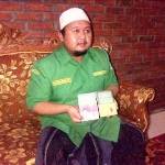 Ketua GP Ansor Bangkalan KH Hasani Zubair menunjukkan buku saku yang disebar ke PAC dan ranting, serta tokoh masyarakat. Foto: imam hambali/BANGSAONLINE