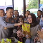 Kapolres Madiun saat membantu warga dalam GPM atau Gerakan Pangan Murah.