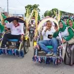 Pasangan Qosim-Alif saat menyapa pendukungnya dengan naik becak. (foto: ist)