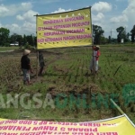 Warga memasang tulisan penolakan pembangunan SMP Negeri 3. foto: AKINA/ BANGSAONLINE