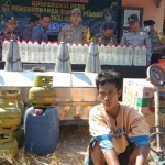 Polres Tuban menggelar pers rilis di lokasi penggerebekan miras. Tampak tersangka Suyono memakai baju tahanan.