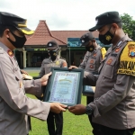 Wakapolres Mojokerto Kota Kompol Dr. Sarwo Waskito menyerahkan penghargaan kepada personel berprestasi saat apel pagi di Lapangan Apel Maha Patih Gajah Mada, Senin (18/10) pagi.