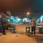 Petugas memasang barikade berupa 5 drum yang dijajar untuk menghalau masuknya pemudik ke wilayah Jember.