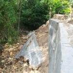 Kondisi plengsengan yang ambrol dibiarkan, menghalangi arus sungai.