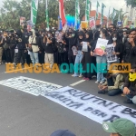 Ribuan massa yang terdiri dari mahasiswa, rakyat sipil, dan suporter menyuarakan aspirasi menolak UU TNI di depan Gedung Negara Grahadi. FOTO: Novandryo/BANGSAONLINE