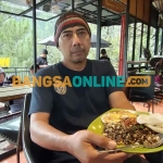 Adi Hasto saat menunjukkan sego tiwul, kuliner khas Kabupaten Kediri. Foto: MUJI HARJITA/BANGSAONLINE