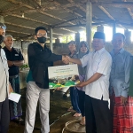 Perwakilan Petrokimia Gresik (kiri) menyerahkan bantuan kepada peternak sapi terdampak wabah PMK. foto: ist.