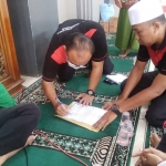 WBP Santos Ardiansyah sedang menandatangani berkas usai proses syahadat di Masjid Baiturrahman Lapas Narkotika Pamekasan.