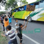 Puluhan anak ramai-ramai meminta sopir bus membunyikan klakson teloletnya. foto: RONY SUHARTOMO/ BANGSAONLINE