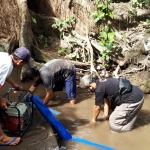 Beny Prasetyo (kaos hitam) bersama tim dan Perangkat Desa Wates Kecamatan Pagu, Kabupaten Kediri, saat membersihkan Sumber Rau. foto: MUJI HARJITA/ BANGSAONLINE