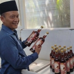 Kuswantoro menunjukkan sirup salak hasil produksinya.