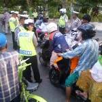 ?Anggota kepolisian membagikan takjil kepada pengguna jalan. Foto:rizal/BANGSAONLINE