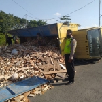 Kondisi truk bermuatan kayu yang terguling di Fly Over Sukodono, Sidoarjo, Senin (26/9/2022).