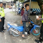 TAK BERKUTIK: Seorang remaja sedang dihentikan anggota Satlantas Polres Bojonegoro karena menggunakan knalpot brong.