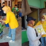 Nik Sugiarti saat menyerahkan sembako kepada tukang becak dan lansia.
