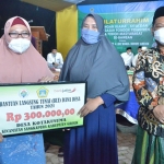 Bupati Gus Yani bersama Wabup Bu Min ketika menyerahkan BPNT untuk warga Sangkapura, Pulau Bawean. (foto: SYUHUD/ BANGSAONLINE)