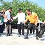Kapolres Gresik AKBP Ramadhan Nasution bersama Bupati Fandi Akhmad Yani saat bersihkan sampah di Pantai Dalegan. foto: ist.