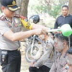 Kapolres Gresik AKBP Wahyu S. Bintoro saat menyiram kepala para Bintara baru. foto: istimewa