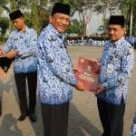 Bupati Gresik, Sambari Halim Radianto, saat menyerahkan piagam kepada 3 orang perwakilan penerima penghargaan Satya Lencana Karya Satya usai upacara HUT RI ke-71 di halaman Kantor Bupati.foto: SYUHUD/ BANGSAONLINE
