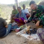Satgas TMMD dan ibu-ibu Desa Kedungsalam saat memasak ayam bakar.