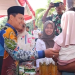 Wakil Wali Kota Pasuruan H. M. Nawawi saat menyapa salah satu warga yang belanja di pasar murah.