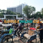 Tukang becak saat antre di lapangan GOR Tri Dharma Petrokimia Gresik untuk mendapatkan bantuan. Foto: SYUHUD/BANGSAONLINE