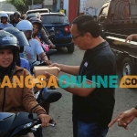 Ketua DPC PDIP Kabupaten Kediri, Murdi Hantoro. saat ikut membagikan takjil kepada pengguna jalan. Foto: MUJI HARJITA/BANGSAONLINE