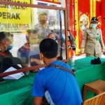 Salah seorang pengguna jalan yang kedapatan tidak mengenakan masker diproses oleh petugas gabungan.