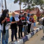 SOLIDARITAS: Anggota AJI Bojonegoro tampak membentangkan poster di depan Mapolres Bojonegoro. Foto: eky nurhadi/BANGSAONLINE