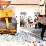Aparat kepolisian Polres Blitar Kota melempar botol minuman keras untuk dimusnahkan. foto: TRI SUSANTO/ BANGSAONLINE