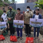 KH Husnul Khuluq dan Wali Kota Probolinggo Habib Hadi serta M. Agus Saifudin foto bersama para penerima bantuan bedah rumah. foto: bangsaonline.com