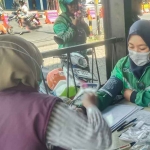 Salah satu driver ojol perempuan saat mengikuti pemeriksaan kesehatan gratis yang digelar Dinkes Batu.