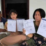  Yunanik (kanan) bersama adik dan suami saat menunjukkan bukti rekening koran dan laporan ke Polda Jatim. Foto: Suwandi/BANGSAONLINE
