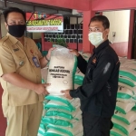 Camat Gurah, Kaleb Satrio Wicaksono (kiri) saat menerima beras bantuan dari petugas BPBD Kabupaten Kediri. foto: ist/ bangsaonline.com